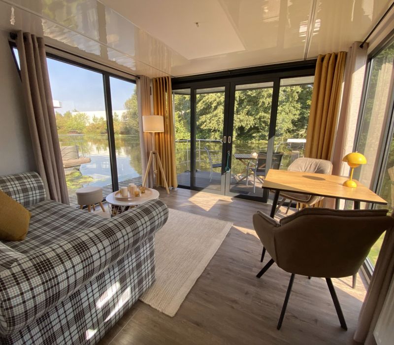 Verglaster Wohnbereich mit Essbereich in unserem Hausboot