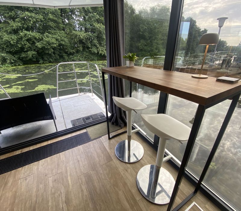 Stühle und Tisch mit Blick auf die Natur rund um die Hausboote von Econ Marine